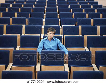 Businessman sitting alone in Auditorium, portrait View Large Photo Image Picture - Businessman sitting alone in Auditorium, portrait. Fotosearch