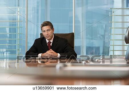 Businessman sitting at conference table, portrait View Large Photo Image Stock Image - Businessman sitting at conference table, portrait. Fotosearch