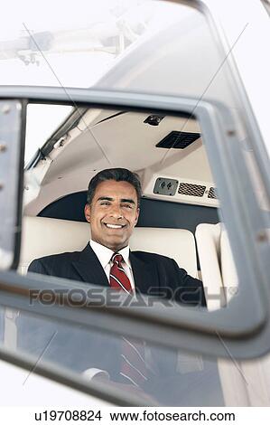 Picture - Businessman sitting in helicopter, portrait. Fotosearch