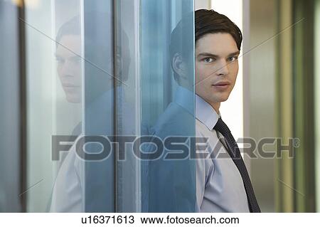 Businessman standing by wall, portrait View Large Photo Image Stock Image - Businessman standing by wall, portrait. Fotosearch