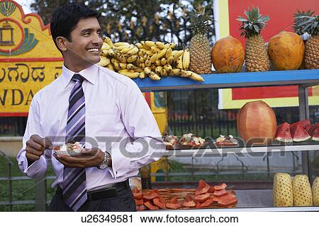 Businessman standing in front of fruit stall View Large Photo Image Stock Image - Businessman standing in front of fruit stall. Fotosearch