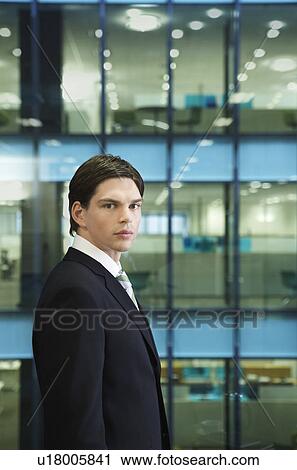 Stock Image - Businessman standing in office, portrait. Fotosearch