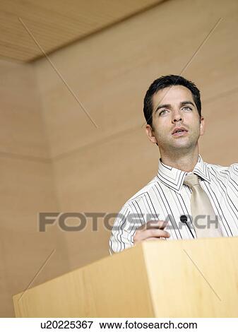 Businessman talking at podium in conference room View Large Photo Image Stock Photo - Businessman talking at podium in conference room. Fotosearch