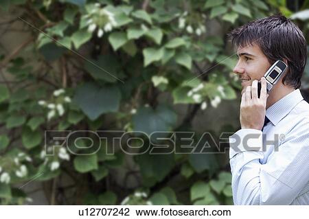 Businessman Talking on Cell Phone in park garden View Large Photo Image Stock Image - Businessman Talking on Cell Phone in park garden. Fotosearch