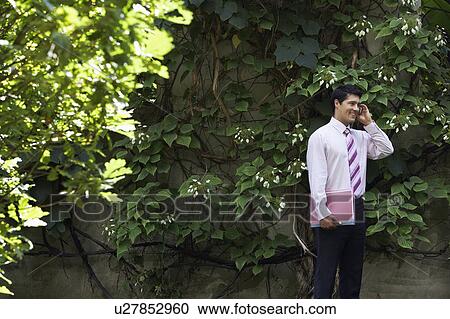 Businessman Talking on Cell Phone in park View Large Photo Image Stock Image - Businessman Talking on Cell Phone in park. Fotosearch