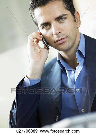 Stock Photo - Businessman Using Cell Phone indoors, portrait. Fotosearch