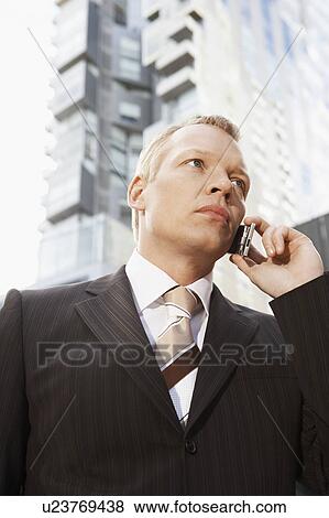 Stock Photo - Businessman using mobile phone, portrait. Fotosearch