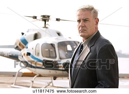 Businessman waiting at helicopter pad View Large Photo Image Stock Photography - Businessman waiting at helicopter pad. Fotosearch