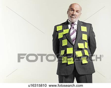 Stock Image - Businessman wearing sticky notes. Fotosearch