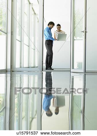 Stock Photo - Businessmen Meeting viewed through open office door. Fotosearch