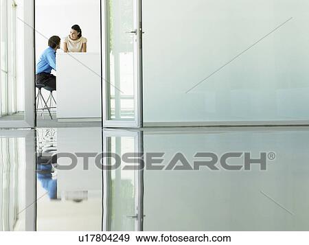 Stock Photo - Businessmen Meeting viewed through open office door. Fotosearch