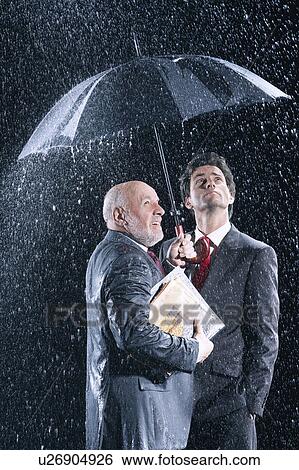 Stock Photograph - Businessmen Watching Rain from Under Umbrella. Fotosearch