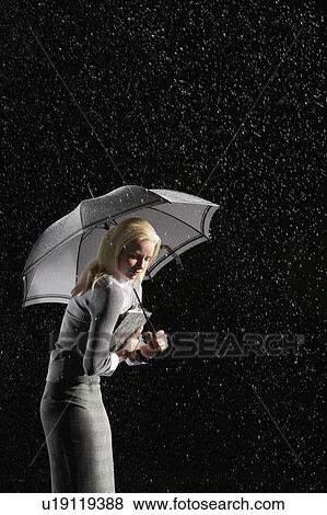 Businesswoman hunching down Under Umbrella for protection from rain View Large Photo Image Stock Photo - Businesswoman hunching down Under Umbrella for protection from rain. Fotosearch