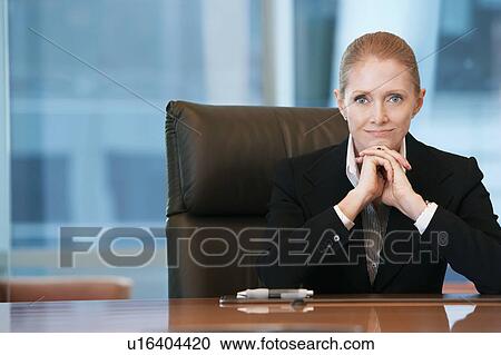 Businesswoman sitting at conference table, portrait View Large Photo Image Stock Image - Businesswoman sitting at conference table, portrait. Fotosearch