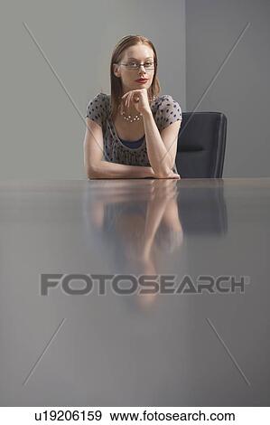Stock Photo - Businesswoman sitting at conference table. Fotosearch