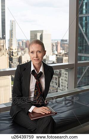 Stock Photo - Businesswoman sitting in office lobby, portrait. Fotosearch