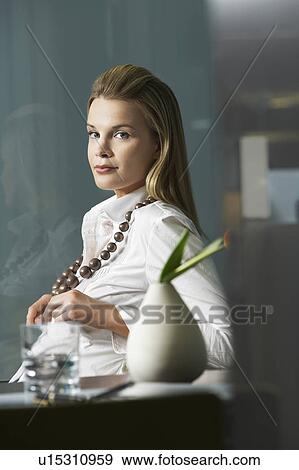 Stock Photo - Businesswoman, sitting in office, portrait. Fotosearch