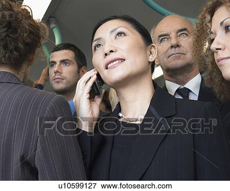 Businesswomen using mobile on train, low angle view View Large Photo Image Stock Photo - Businesswomen using mobile on train, low angle view. Fotosearch
