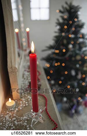 Stock Image - Candles Burning on mantelpiece, close up. Fotosearch