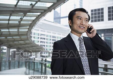 China, Hong Kong, business man using mobile phone, standing on footbridge View Large Photo Image Stock Photo - China, Hong Kong, business man using mobile phone, standing on footbridge. Fotosearch