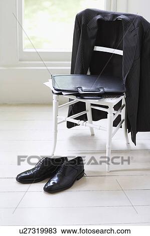 Stock Image - Clothing of businessman on chair and floor. Fotosearch