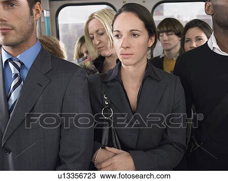 Stock Image - Commuters standing on a Train. Fotosearch
