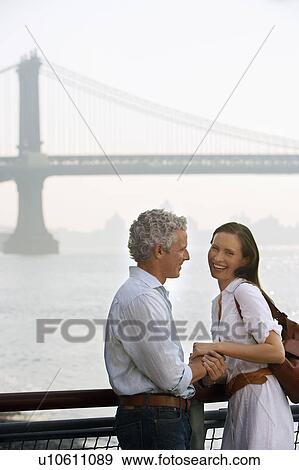 Stock Photo - Couple holding hands by river. Fotosearch