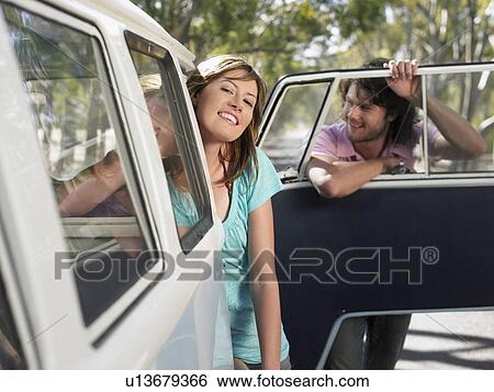 Couple leaning out of van parked by side of road View Large Photo Image Stock Photograph - Couple leaning out of van parked by side of road. Fotosearch