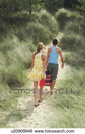 Couple Leaving Beach on Trail, high angle view, back view View Large Photo Image Stock Photo - Couple Leaving Beach on Trail, high angle view, back view. Fotosearch