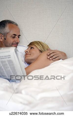 Couple looking in each others eyes, lying in bed View Large Photo Image Stock Photography - Couple looking in each others eyes, lying in bed. Fotosearch