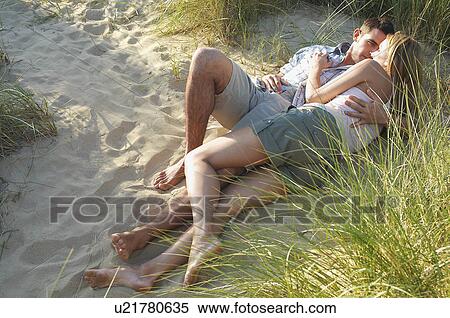 Couple lying and embracing in Secluded Spot on Beach, high angle view View Large Photo Image Stock Photography - Couple lying and embracing in Secluded Spot on Beach, high angle view. Fotosearch