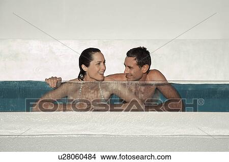 Picture - Couple relaxing in swimming pool together. Fotosearch