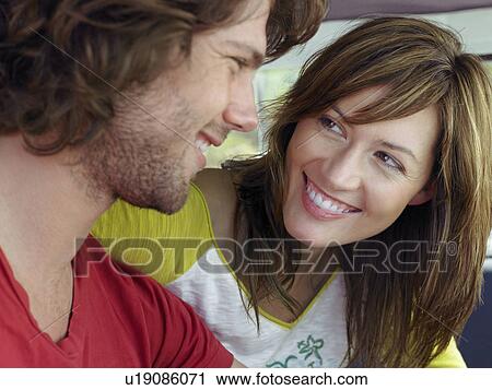 Couple smiling at each other, head and shoulders View Large Photo Image Stock Image - Couple smiling at each other, head and shoulders. Fotosearch