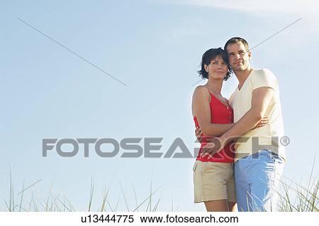 Couple Standing in Tall Grass looking at view, portrait View Large Photo Image Stock Photography - Couple Standing in Tall Grass looking at view, portrait. Fotosearch