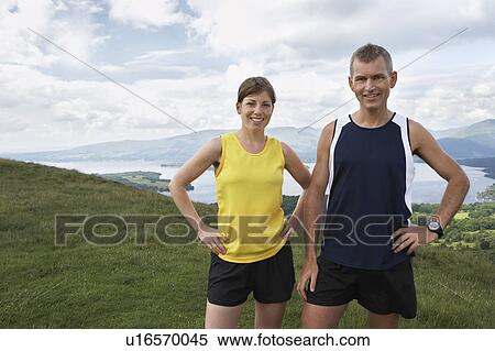 Stock Photography - Couple standing on hillside, portrait. Fotosearch