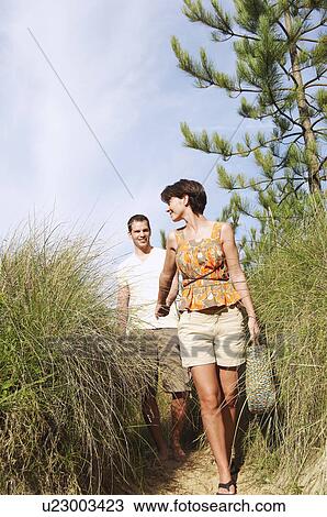 Couple walking on trail to beach View Large Photo Image Stock Image - Couple walking on trail to beach. Fotosearch