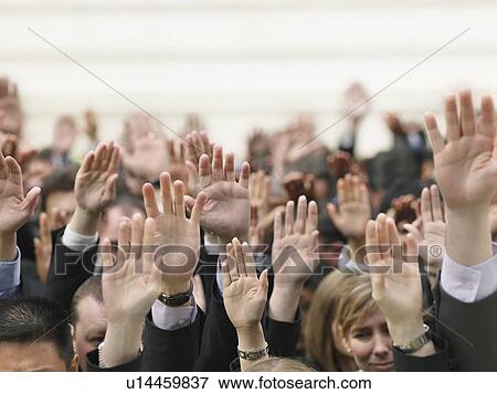 Stock Photo - Crowd of people raising hands, focus on hands. Fotosearch
