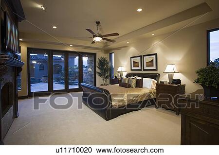 Stock Image - Dark wood furniture in bedroom with ceiling fan. Fotosearch
