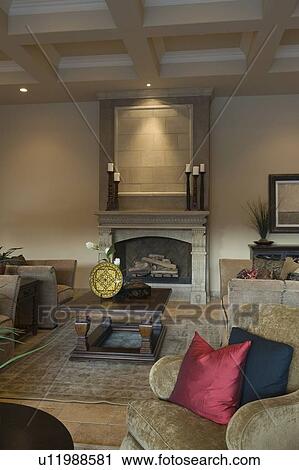 Stock Image - Darkly lit living room with fireplace. Fotosearch
