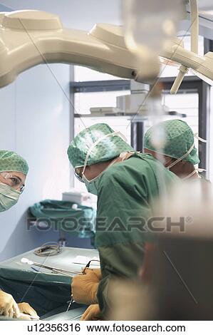 Stock Photograph - Doctors in Surgery, viewed from behind IV stand. Fotosearch