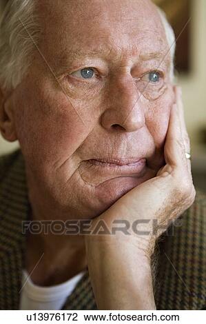Stock Image - Elderly man leaning head on his hand. Fotosearch