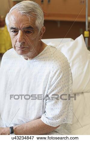 Elderly man sitting on hospital bed View Large Photo Image Stock Photo - Elderly man sitting on hospital bed. Fotosearch