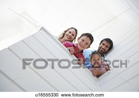 Family peering over white wall, view from below View Large Photo Image Stock Image - Family peering over white wall, view from below. Fotosearch