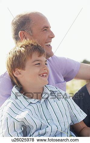 Father and Son sitting on beach looking at view, portrait View Large Photo Image Stock Photo - Father and Son sitting on beach looking at view, portrait. Fotosearch