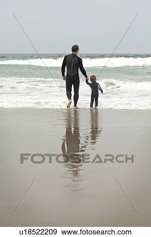 Father and son walk into the sea View Large Photo Image Stock Photo - Father and son walk into the sea. Fotosearch
