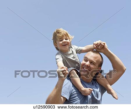 Father carries son on his shoulders, CA View Large Photo Image Stock Image - Father carries son on his shoulders, CA. Fotosearch
