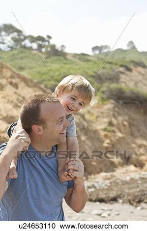 Stock Image - Father carries son on his shoulders, CA. Fotosearch