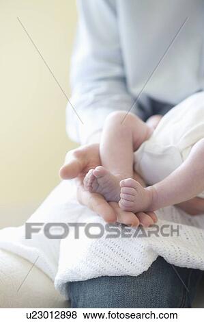 Father holding feet of two week old baby View Large Photo Image Stock Photo - Father holding feet of two week old baby. Fotosearch