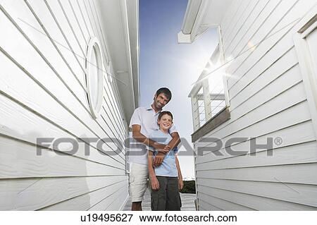 Father standing behind son in narrow passageway between houses View Large Photo Image Stock Photo - Father standing behind son in narrow passageway between houses. Fotosearch