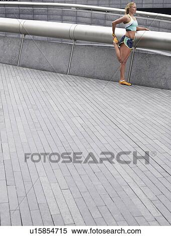 Female athlete stretching, outdoors, side view View Large Photo Image Stock Photography - Female athlete stretching, outdoors, side view. Fotosearch